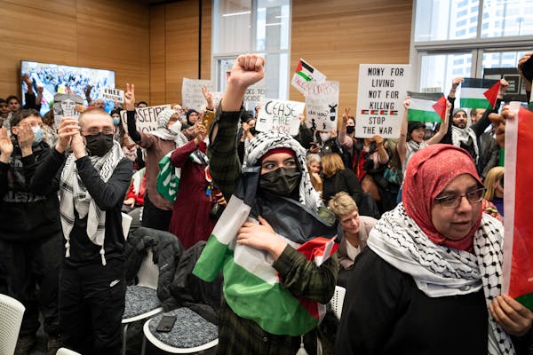 Supporters of a resolution calling for a cease-fire in Gaza stand during Minneapolis City Council's first meeting of 2024 in Minneapolis, Minn. Monday