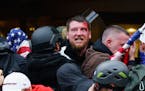 A rioter is bleeding after an injury sustained while trying to push past police through the doorway of the U.S. Capitol Building in Washington, D.C., 