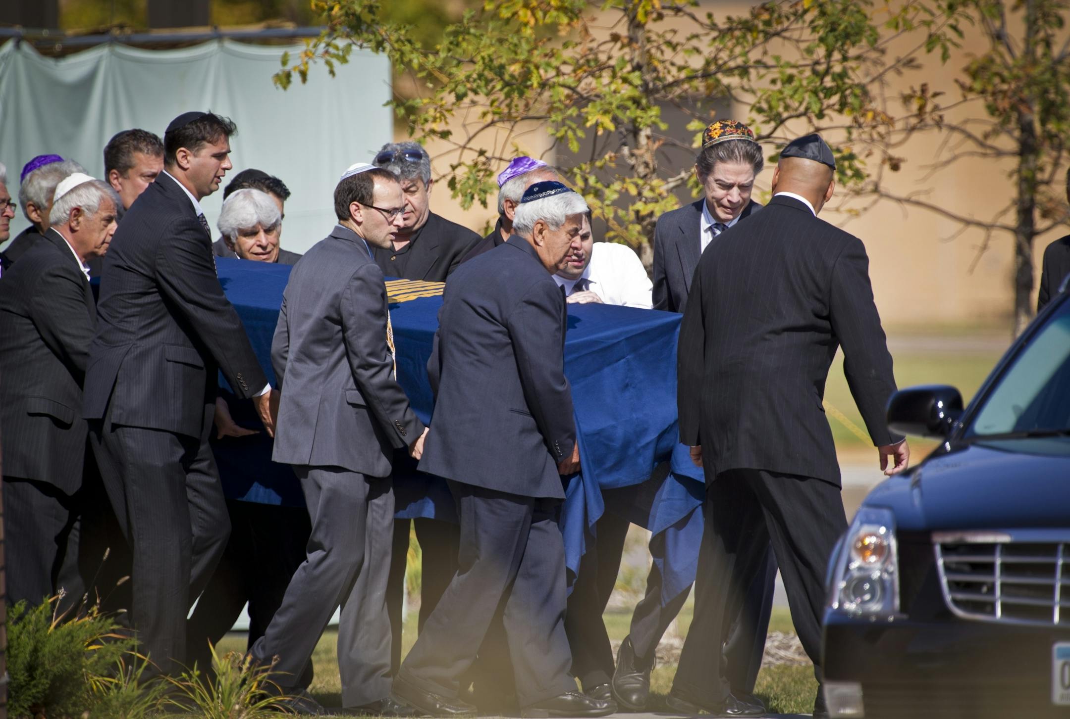 Pallbearers carried the casket of Reuven Rahamim, who died in a workplace shooting last week, to the hearse at Beth El Synagogue in St. Louis Park, Minn., on Sunday. Rahamim will be buried in his homeland of Israel.