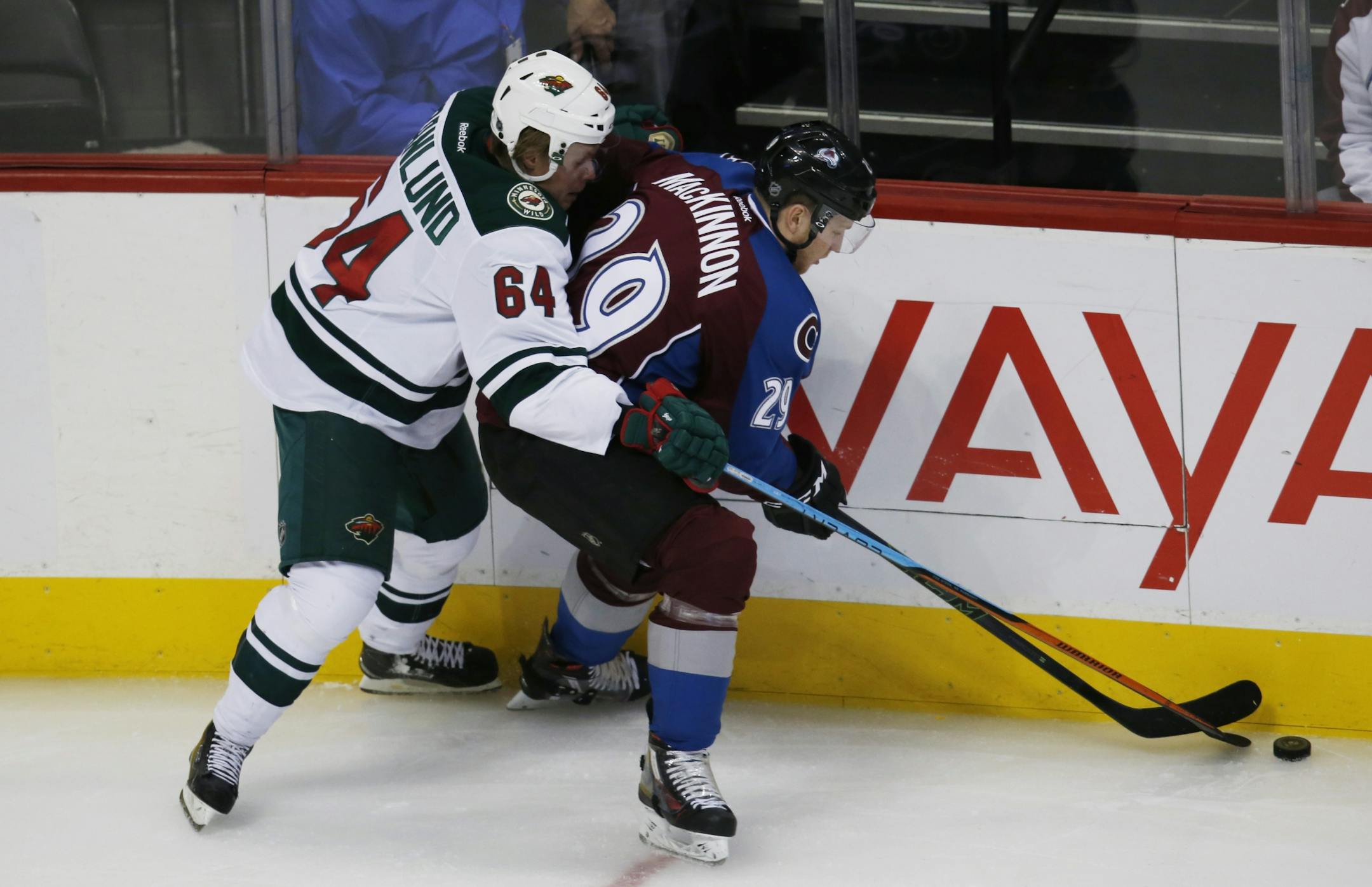 Minnesota Wild center Mikael Granlund, left, of Finald, battles for control of the puck with Colorado Avalanche center Nathan MacKinnon, right, in the first period of an NHL hockey game Monday, Dec. 7, 2015, in Denver.
