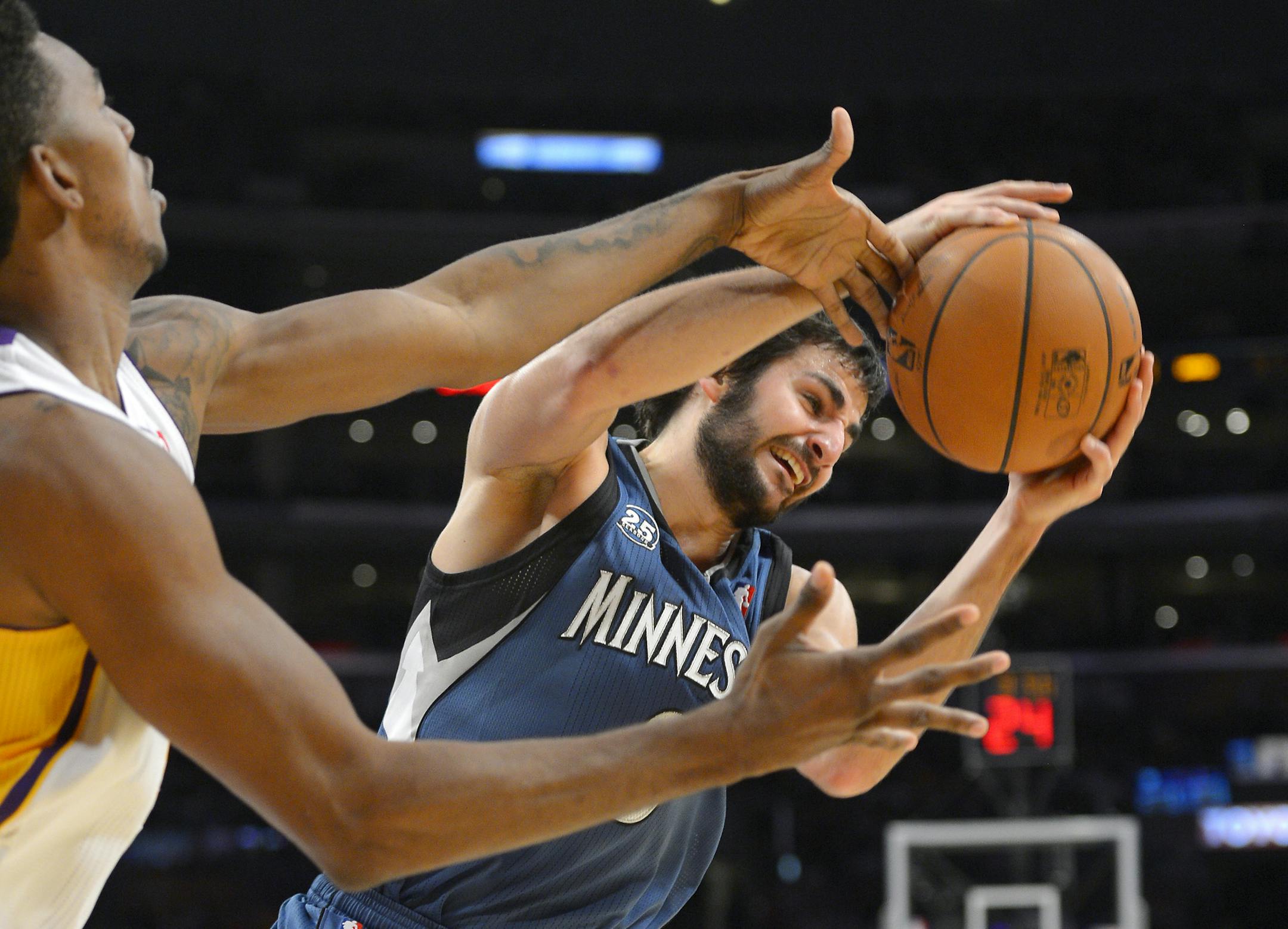Minnesota guard Ricky Rubio grabs a rebound away from Los Angeles Lakers forward Nick Young.