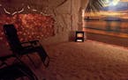 A salt cave at Bella Vita in downtown St. Cloud features Himalayan salt on the floors and walls, a calming beach scene and small salt particles disper