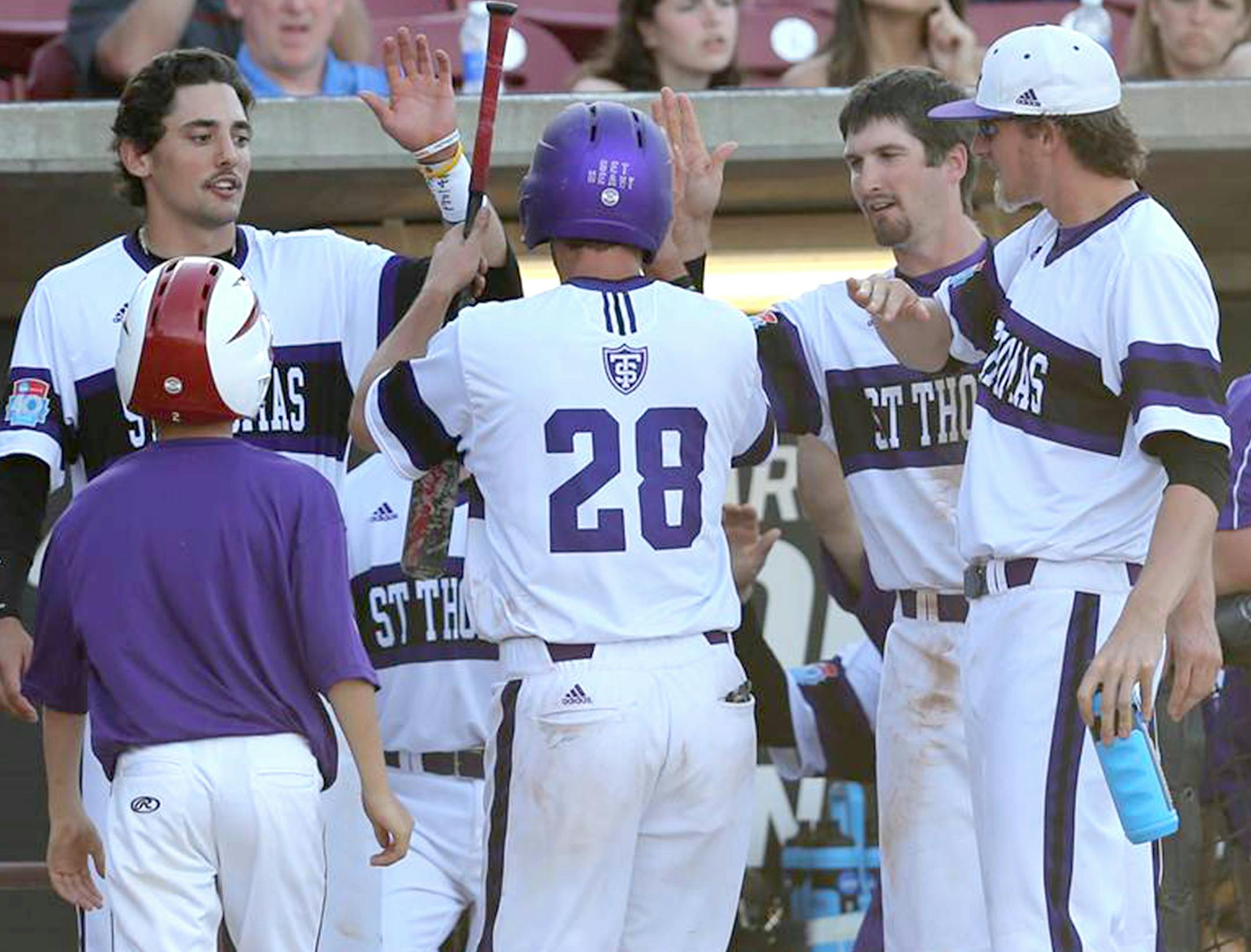 Brady Johnson (28) gets congrats from teammates as he scored to break a 3-3 tie in the seventh inning following Ben Podobinski's two-out single. (Larry Radloff photo)