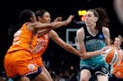 The New York Liberty’s Breanna Stewart (30) controls the ball as the Connecticut Sun’s Tiffany Hayes (15) and Olivia Nelson-Ododa (10) defend in t