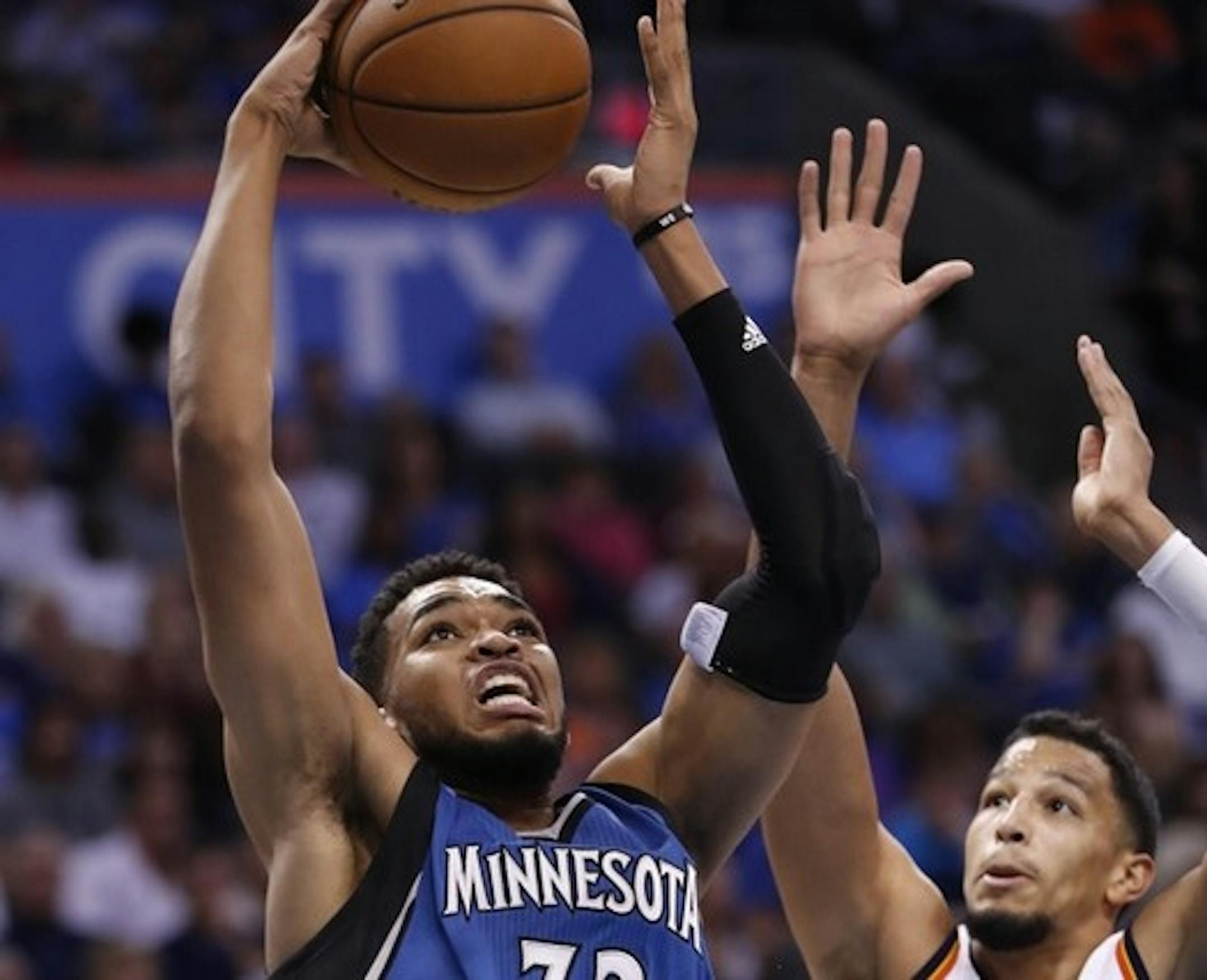 Timberwolves center Karl-Anthony Towns (32) goes to the basket ahead of Oklahoma City Thunder guard Andre Roberson