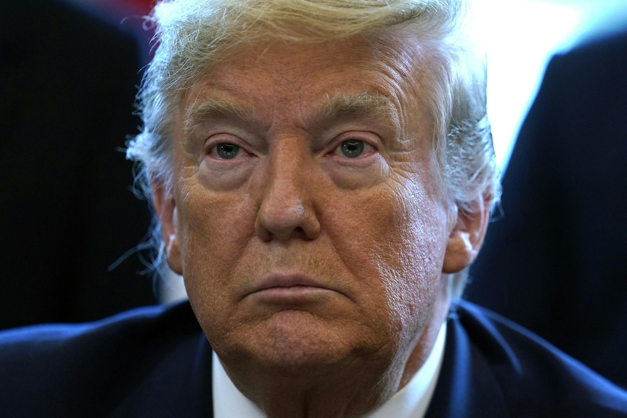 FILE - In this March 27, 2020, file photo President Donald Trump listens before he signs the coronavirus stimulus relief package in the Oval Office at the White House in Washington. Trump has framed his fight against the pandemic as a war, and himself a wartime president. But rather than fully lever the power of the federal government, he has increasingly put responsibility on the states, reigniting the kind of tension the nation’s founders wrestled with more than two centuries ago. (AP P