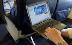 FILE - This is a July 29, 2002 file photo of a laptop is used on a plane . Britain's government Tuesday March 21, 2017 banned electronic devices in th