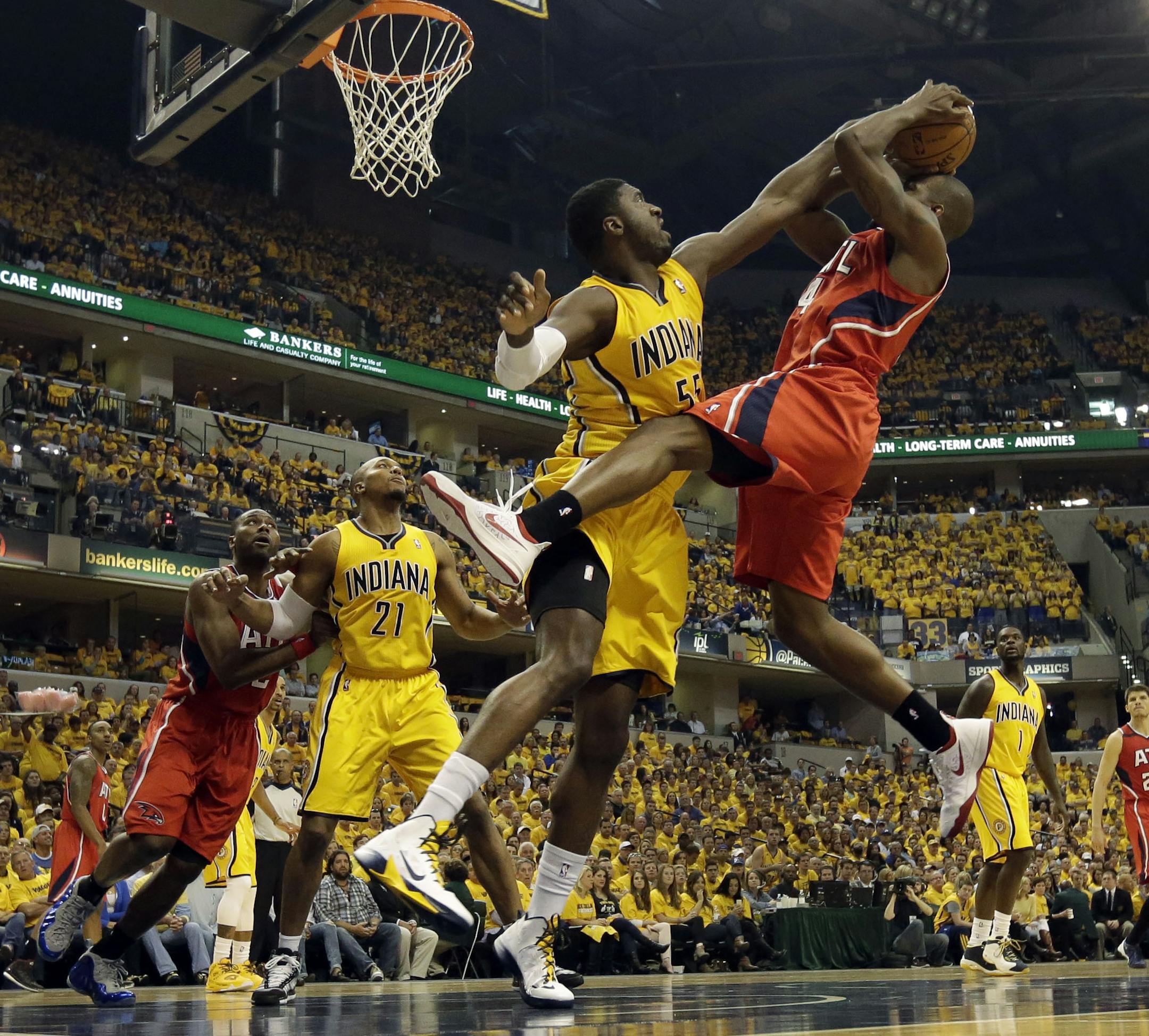 Indiana Pacers center Roy Hibbert, front left, tries to block the shot of Atlanta Hawks forward Paul Millsap during the first half in Game 7 of a first-round NBA basketball playoff series in Indianapolis, Saturday, May 3, 2014. (AP Photo/AJ Mast)