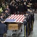 Fargo, N.D., police officers remove the American flag from the casket of 33-year-old slain police officer Jason Moszer during his funeral services Mon