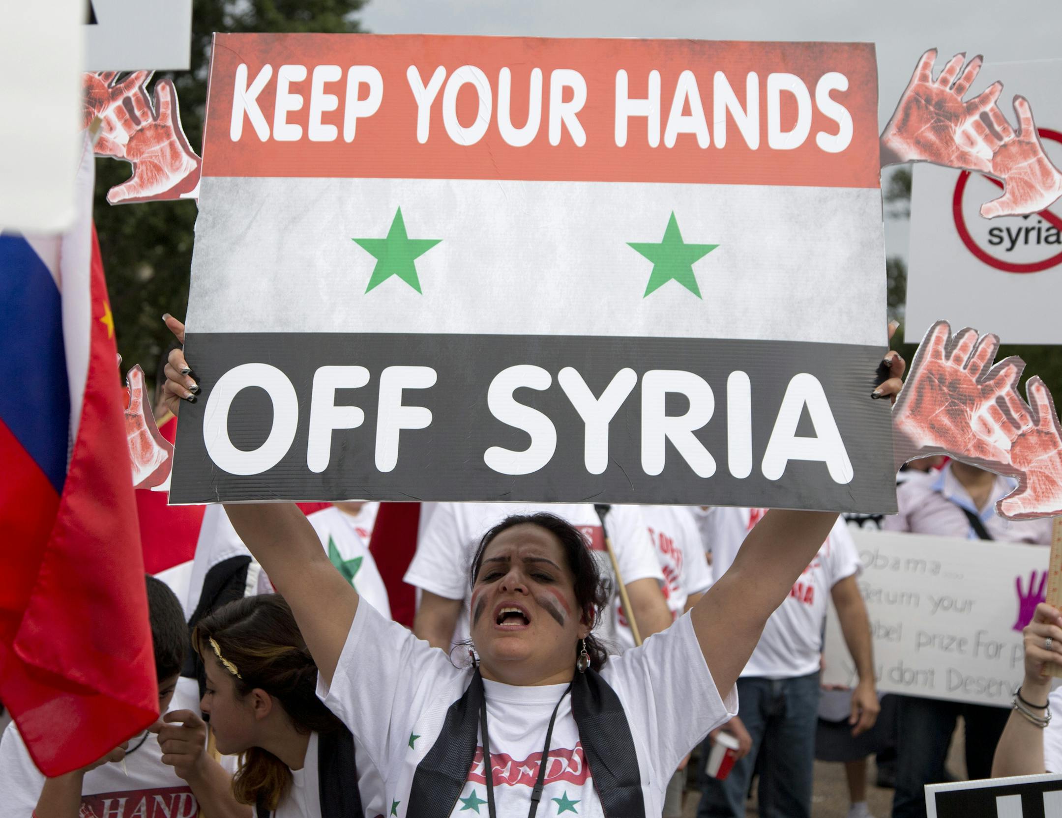Protesters against U.S. military action in Syria shout during a demonstration in front of the White House in Washington, Sept. 9, 2013.