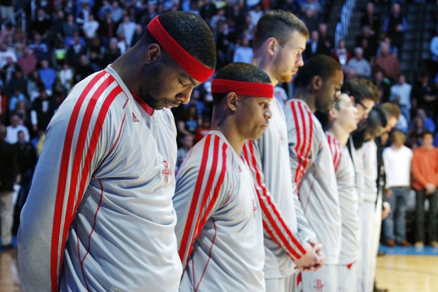 Houston Rockets forward Marcus Morris and teammates bow their heads during a moment of silence for the late daughter of head coach Kevin McHale, Sasha, before their NBA basketball game against the Oklahoma City Thunder in Oklahoma City, Wednesday, Nov. 28, 2012. Oklahoma City won 120-98. The Rockets began the day by attending Sasha McHale's funeral in Minnesota that followed her death Saturday at age 23 of complications from lupus.