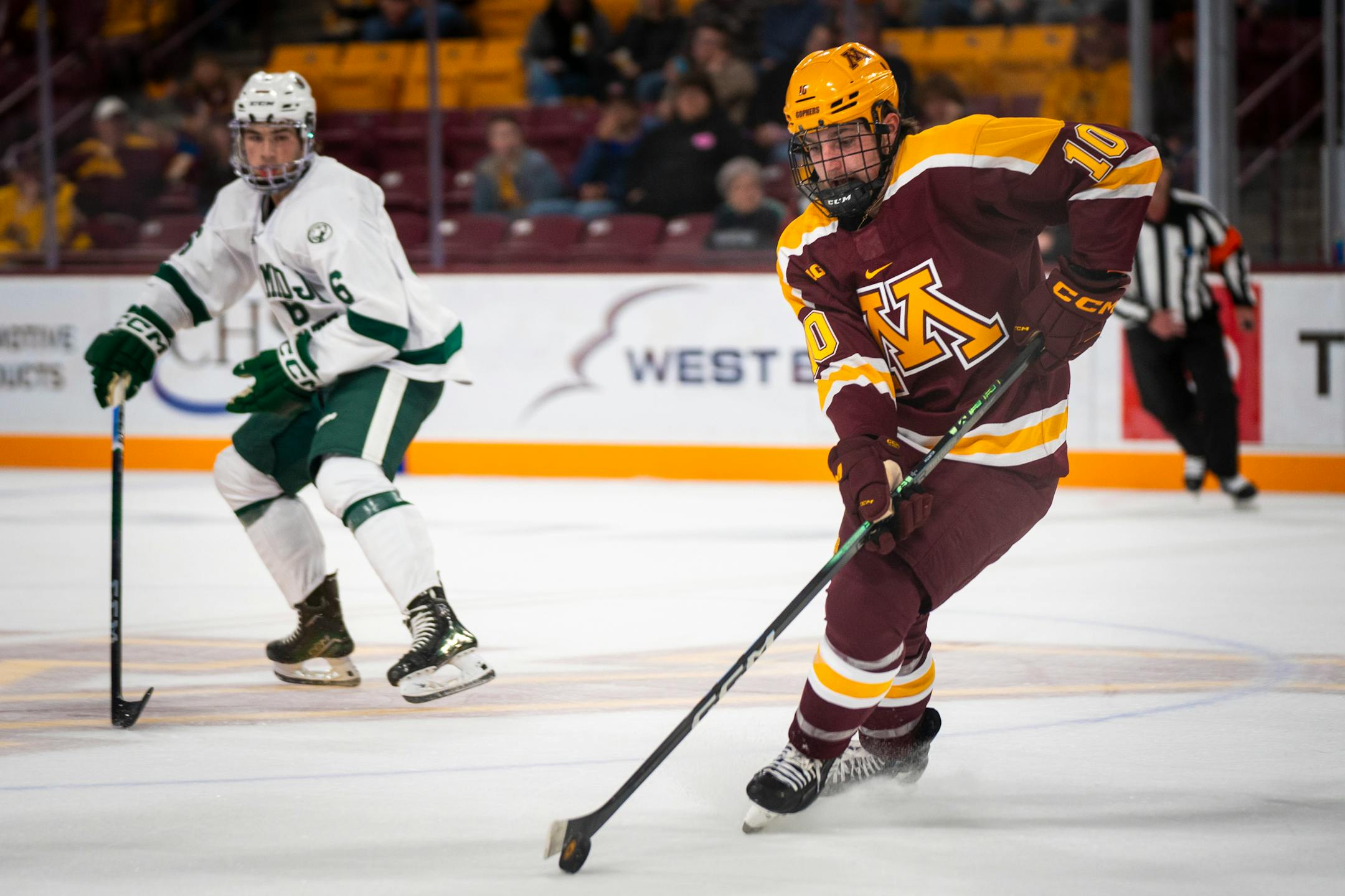 Minnesota Forward Connor Kurth (10) keeps the puck from Bemidji State University players.