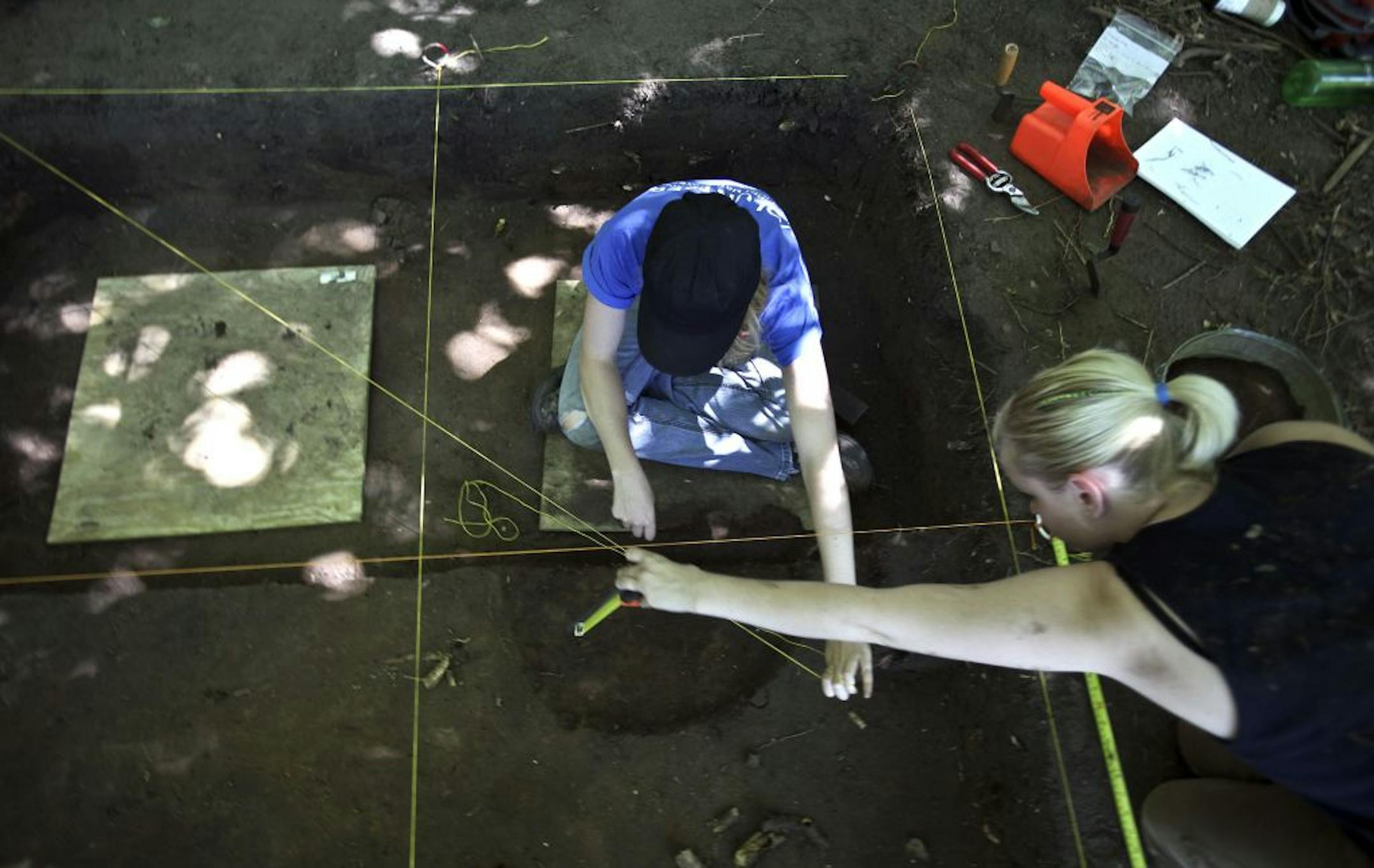University of Minnesota anthropology students Erin Pruhs (cq), left, and Julia Ramberg (cq) measured the depth of the site the were excavating at an archaeological dig along Spring Lake near Hastings , Minn., Tuesday, July 26, 2011.