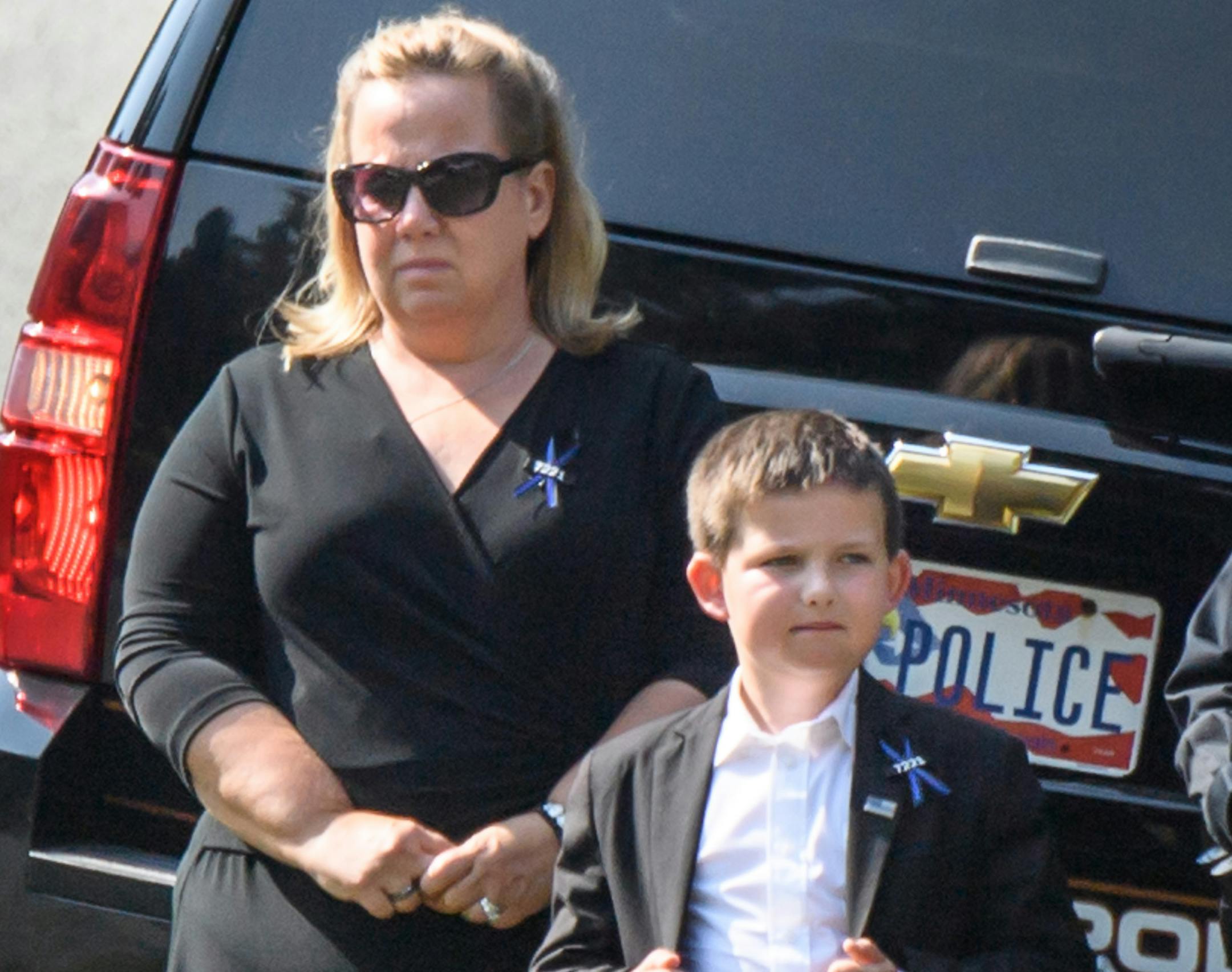 Shawn Mathews and her son Wyatt waited for her husband's casket to arrive for burial ceremony at Summit Park Cemetery. ] GLEN STUBBE • glen.stubbe@startribune.com Thursday, September 14, 2017 Funeral of Wayzata Officer William Mathews is at Wayzata Free Church (11 a.m.), followed by a procession and burial at Summit Park Cemetery.