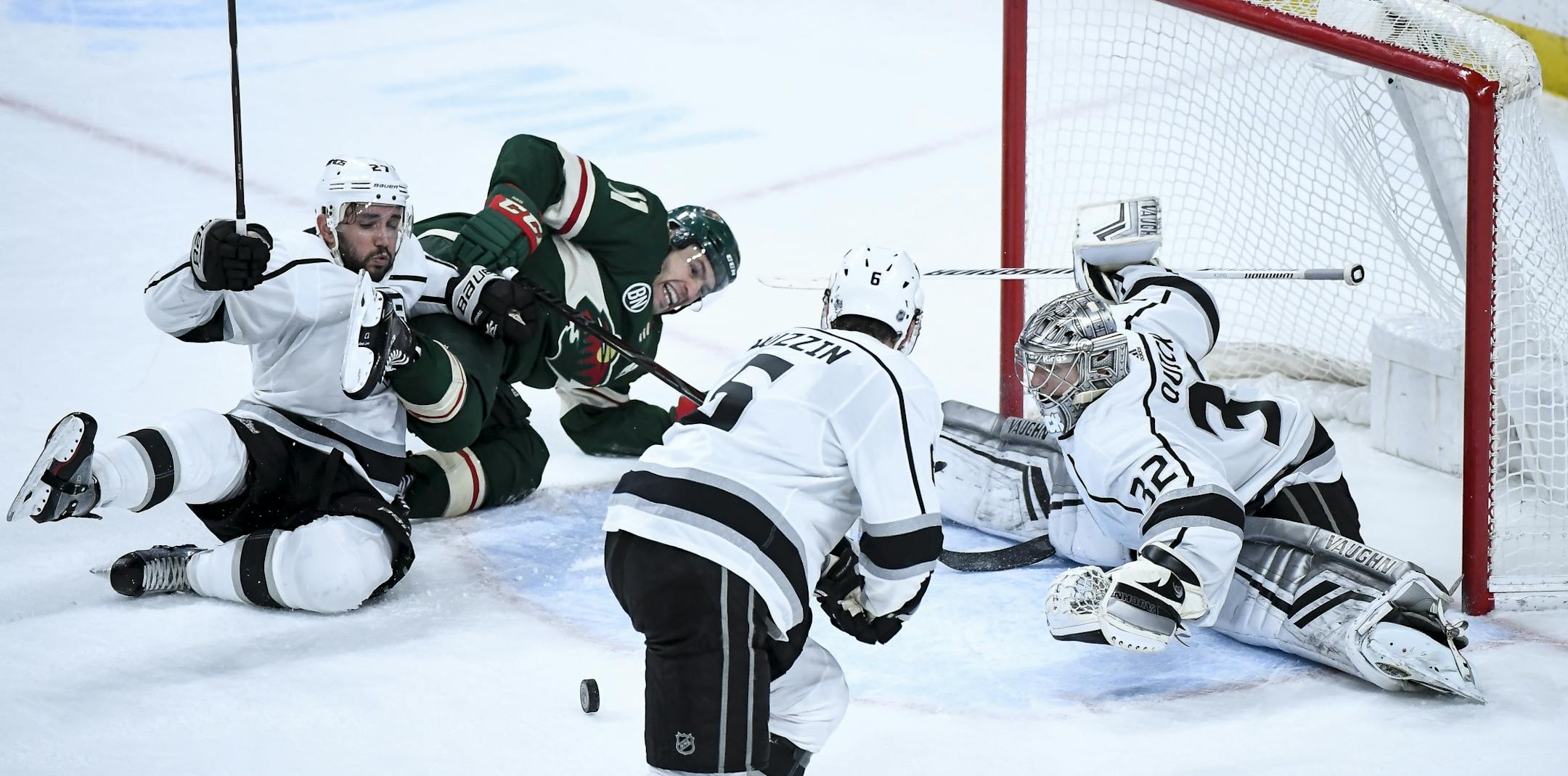 Minnesota Wild left wing Zach Parise (11) was knocked off his skates by Los Angeles Kings defenseman Alec Martinez (27) as Parise attempted a shot against Los Angeles Kings goaltender Jonathan Quick (32) in overtime.