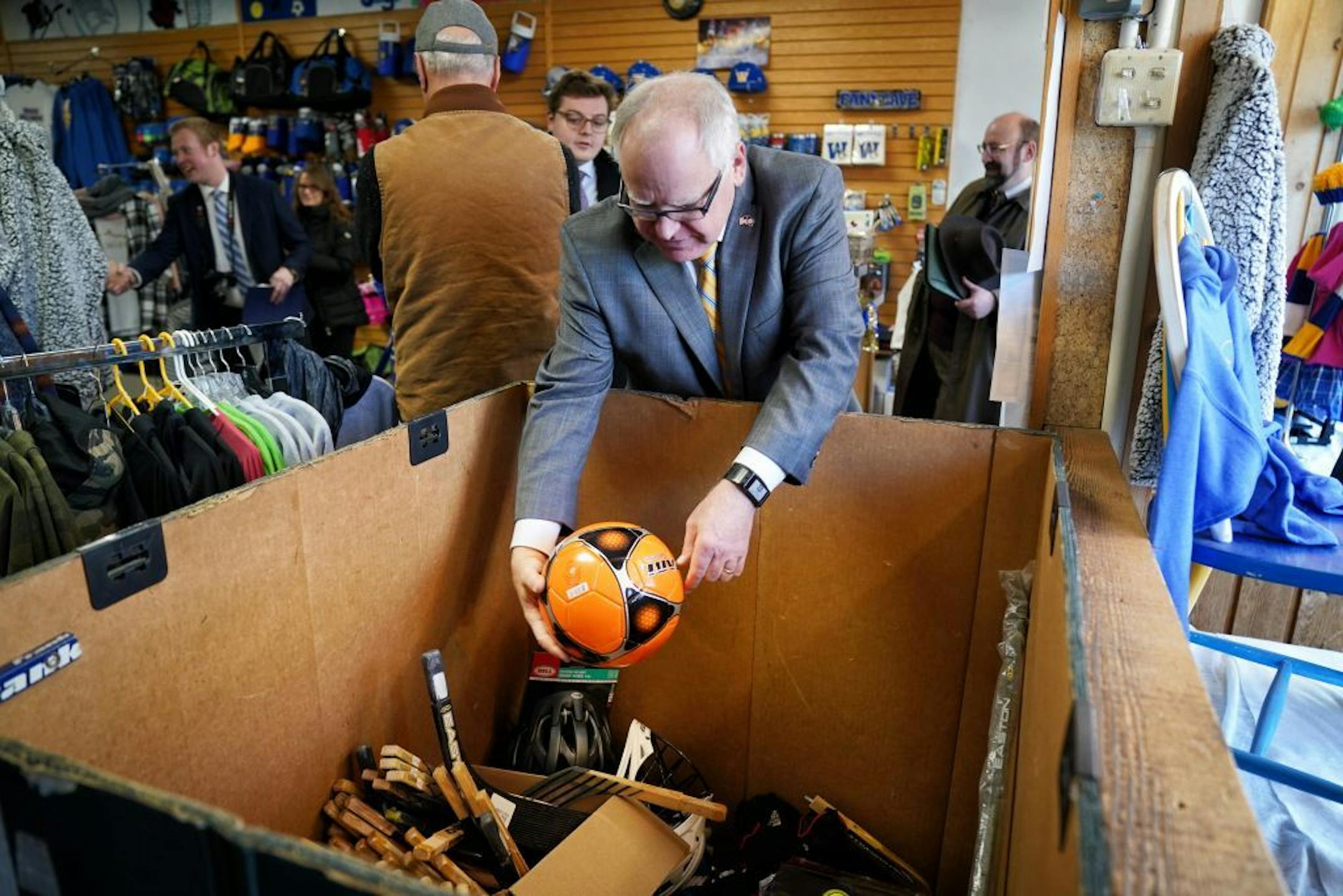 Minnesota Governor Tim Walz bought a soccer ball to donate to United Heroes League and bought a Waseca Bluejays knit hat for himself while visiting 4-Seasons Athletics on North State St., Waseca. On the right is the stores owner Jeremiah Miller. Walz was touring Waseca businesses with Mayor Roy Srp. United Heroes League provides athletic equipment for the children of people serving in the military.