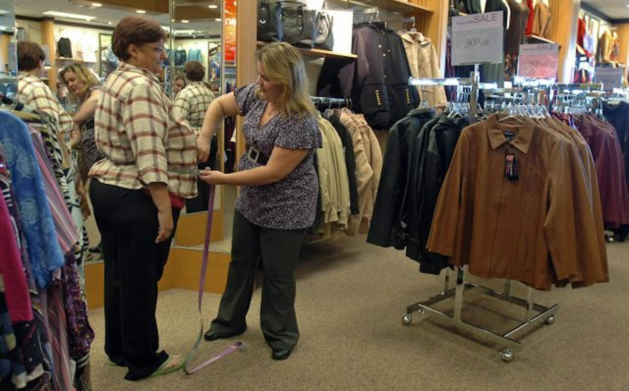 Kathy Murr gets measured using a new measuring tape for plus size women to get them a more tailored fit in Colorado Springs, Colorado, Thursday, September 13, 2007. The sizes come in three different color-coded categories.