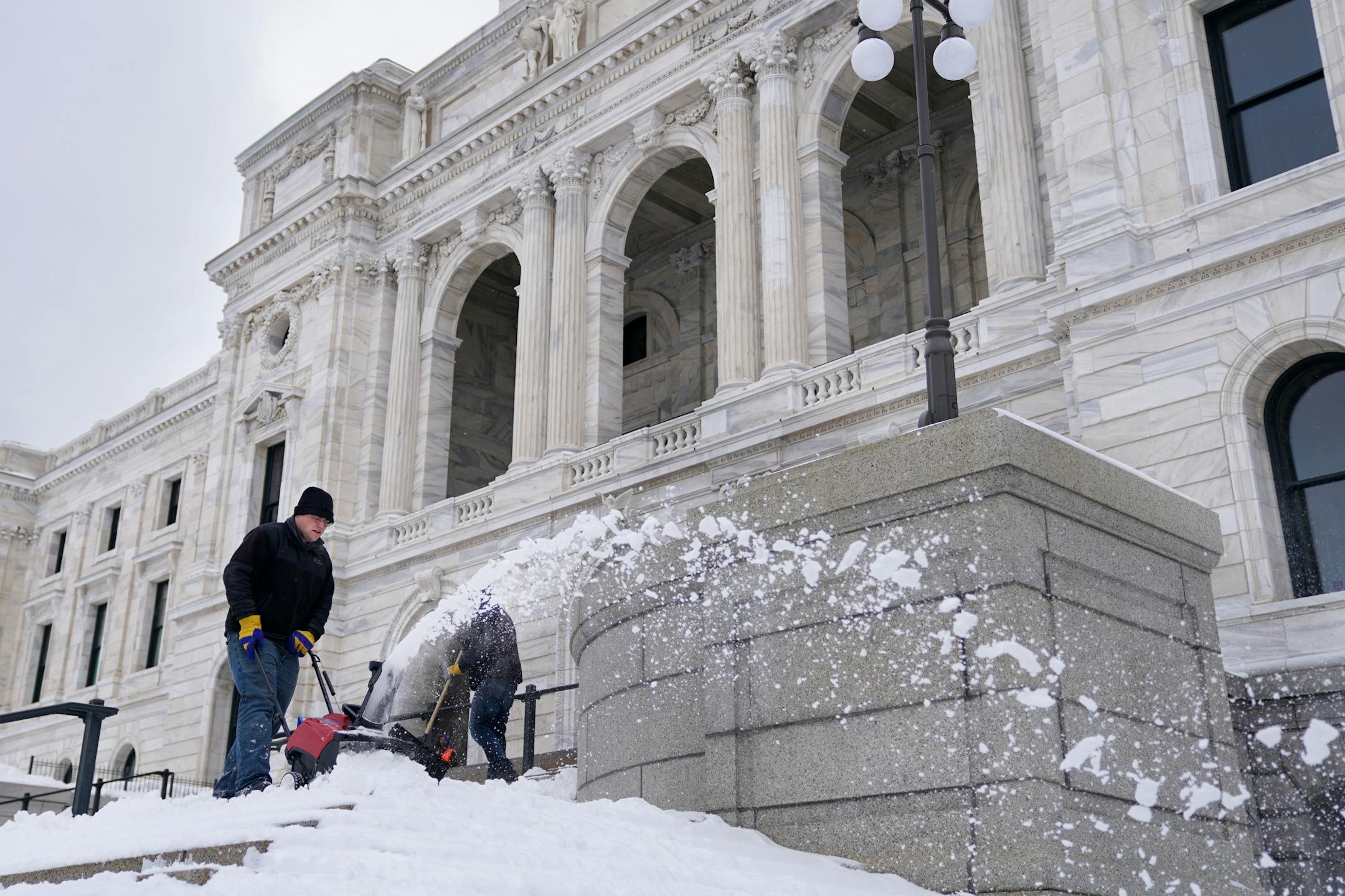 Crews worked to clear snow from the steps of the Minnesota State Capitol before the first day of the legislative session Tuesday.