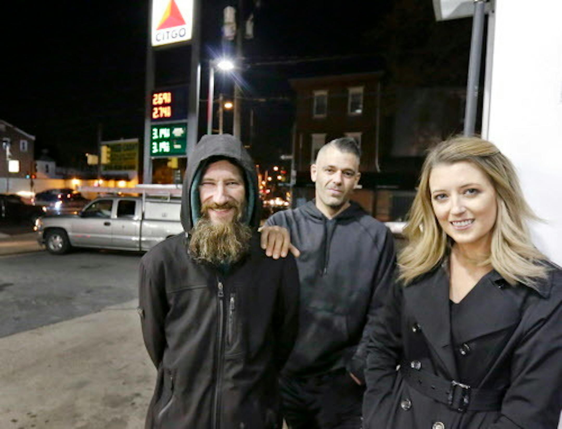 In this November 17, 2017, file photo, Johnny Bobbitt Jr., left, Kate McClure, right, and McClure's boyfriend Mark D'Amico pose at a Citgo station in Philadelphia. The story of Bobbitt, a homeless man who reportedly used his last $20 to fill the gas tank of a stranded McClure, drew worldwide attention. It turned out to be a scam.