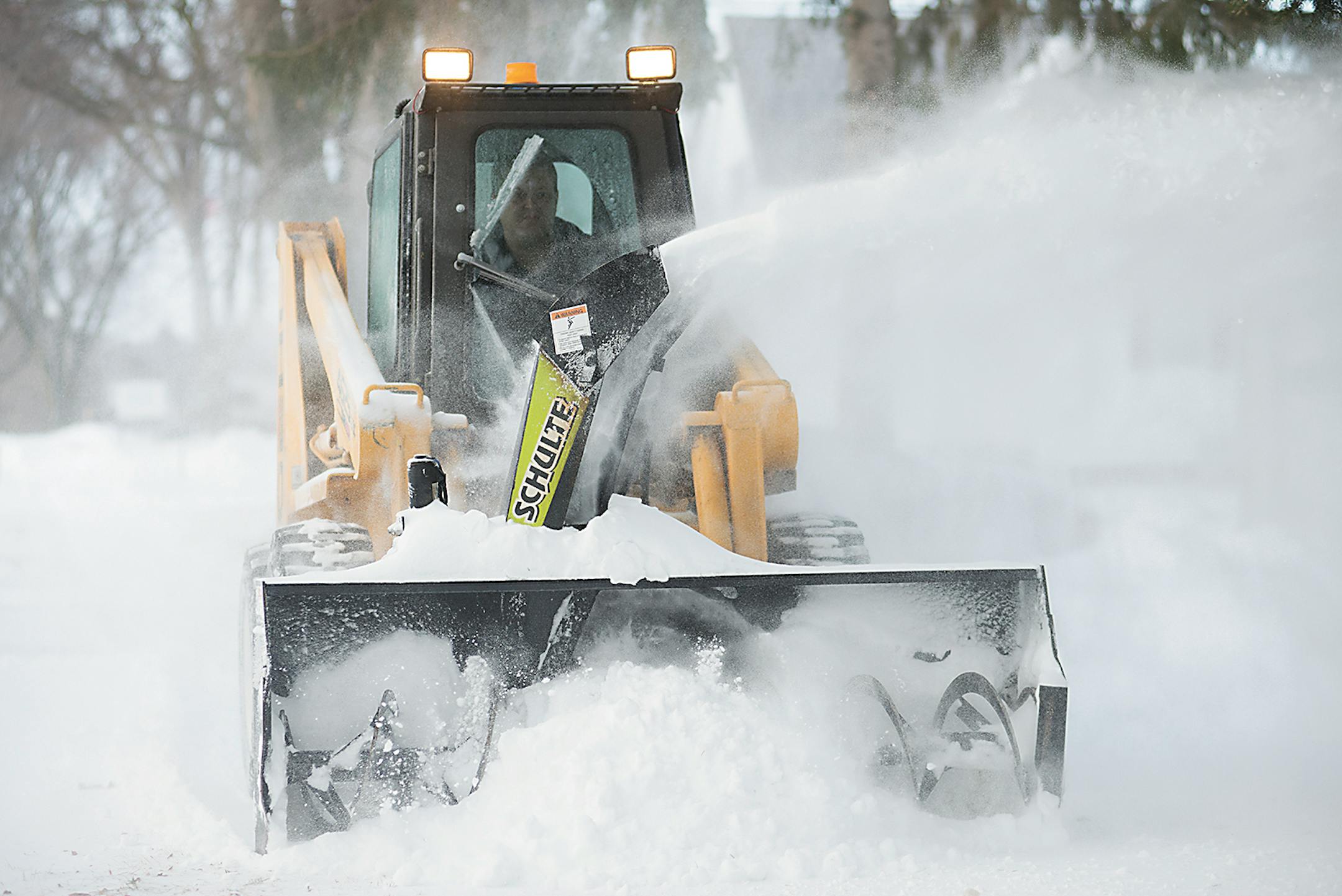 A plow clears snow from a sidewalk, Tuesday in Fergus Falls, Minn.