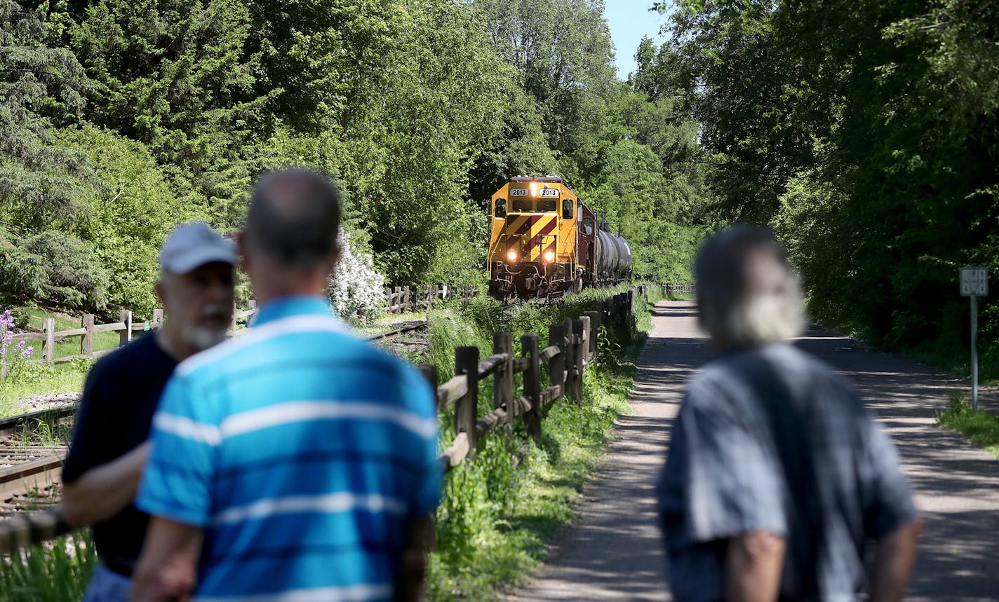 While talking about the proposed Southwest light rail, Paul Petzschke, right to left, and Nick Shuraleff, residents at the Calhoun-Isles condo complex, and neighbor Doug Peterson, encountered a train pulling seemingly empty oil tanker cars near the condo complex Wednesday, May 31, 2017, in Minneapolis, MN. &#xec;I&#xed;m just very concerned about how the vibrations are going to hit this building,&#xee; said Petzschke, a retired engineer, referring to the nearby condo right rise and the proposed