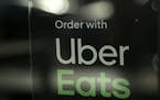 FILE - In this Nov. 6, 2019, file photo, a restaurant advertises Uber Eats in the Coconut Grove neighborhood in Miami. The Wall Street Journal reports