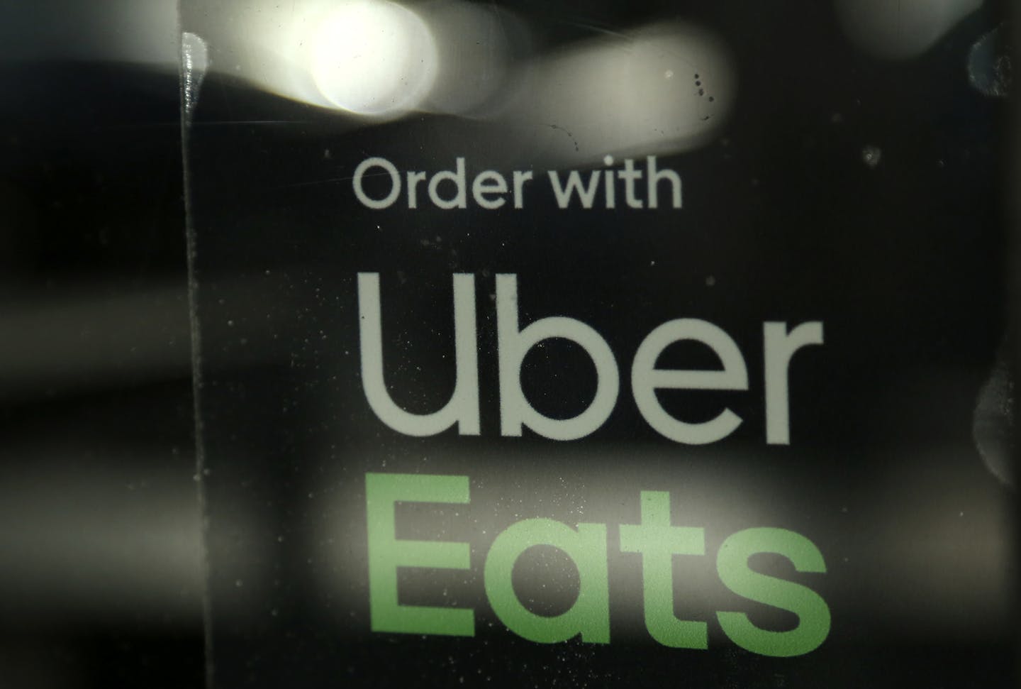 FILE - In this Nov. 6, 2019, file photo, a restaurant advertises Uber Eats in the Coconut Grove neighborhood in Miami. The Wall Street Journal reports that Uber is considering acquiring Grubhub in a deal that would give the companies control over a majority of the U.S. food delivery business. Citing anonymous sources, the newspaper says Uber approached Grubhub earlier this year with an all-stock takeover offer. (AP Photo/Lynne Sladky, File)