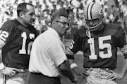 Green Bay Packer coach Vince Lombardi, center, speaks with quarterback Bart Starr (15) and Zeke Bratkowski, left, as the Packers trailed the Detroit L