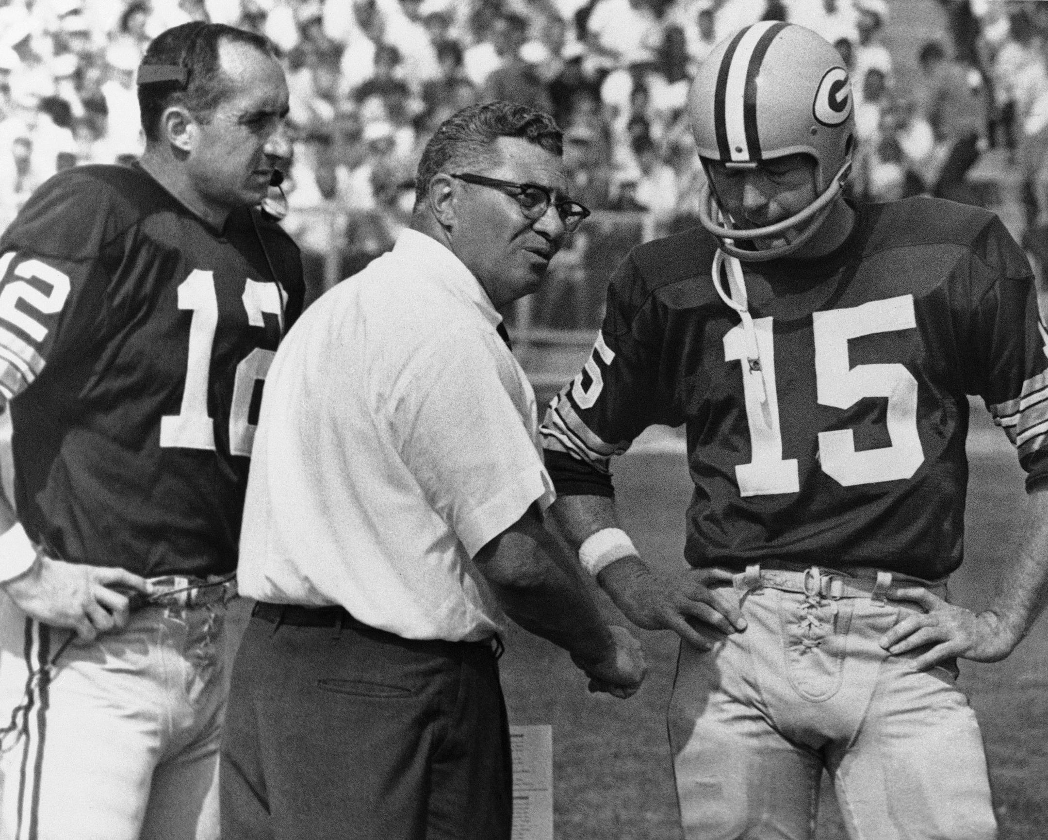 Green Bay Packer coach Vince Lombardi, center, speaks with quarterback Bart Starr (15) and Zeke Bratkowski, left, as the Packers trailed the Detroit Lions at Green Bay, Sept. 18, 1967. The Lions led most of the game, but the Packers managed to catch up in fourth quarter and the contest ended in a 17-17 tie. (AP Photo) ORG XMIT: APHS246992