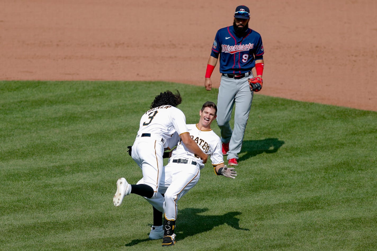 Pittsburgh's Kevin Newman, center, topples over as Cole Tucker celebrates in front of Twins left fielder Marwin Gonzalez, after Newman drove him and Bryan Reynolds in with a game-winning single