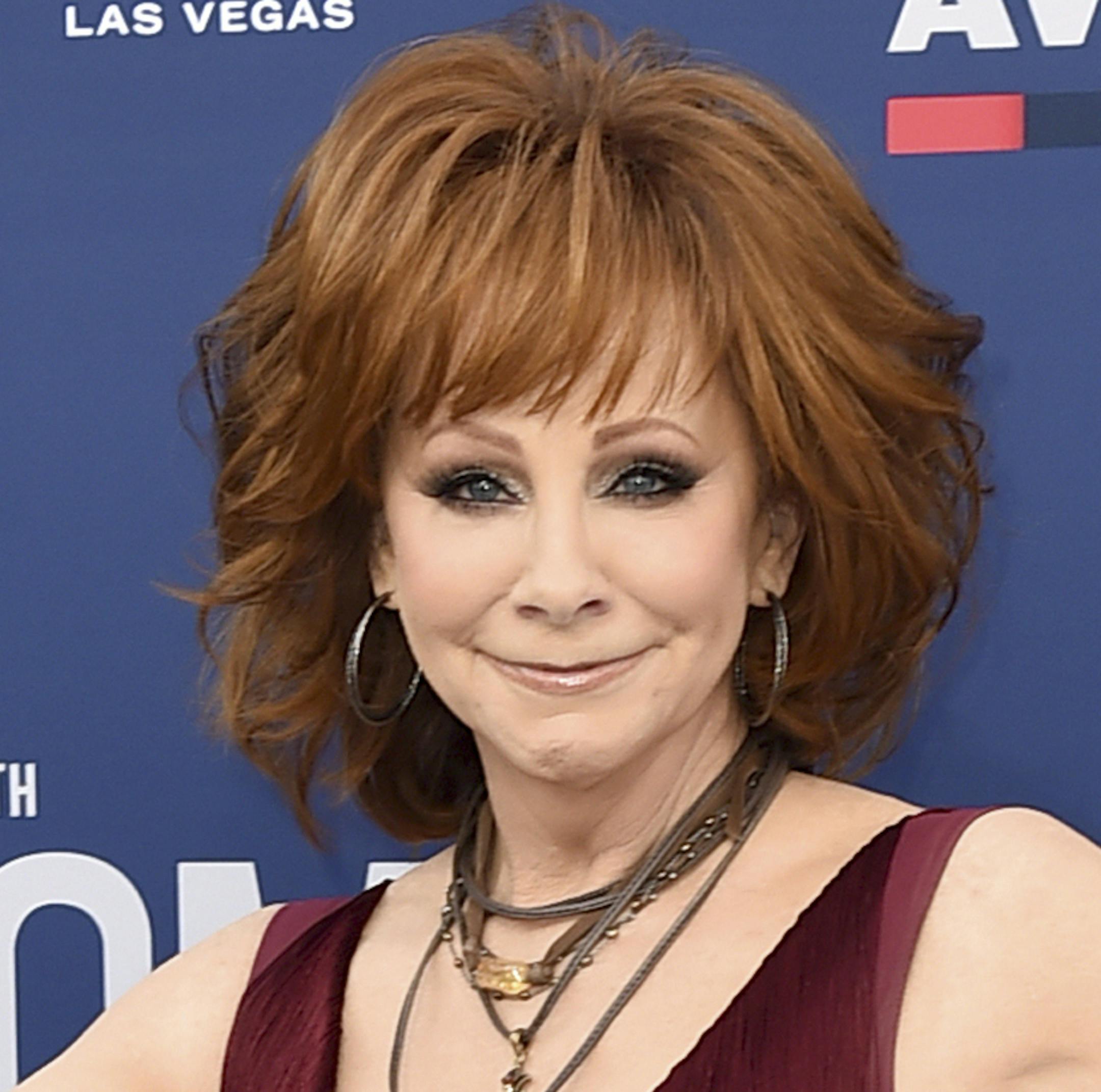 FILE - In a Sunday, April 7, 2019 file photo, Reba McEntire arrives at the 54th annual Academy of Country Music Awards at the MGM Grand Garden Arena, in Las Vegas. The CMAs announced Monday, August 19, 2019 that “special guest hosts” Dolly Parton and Reba McEntire will join Carrie Underwood during the Nov. 13 event. The organization says the show will celebrate “legendary women in Country Music throughout the ceremony.” (Photo by Jordan Strauss/Invision/AP, File)