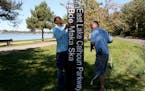 Minneapolis parks employees Dan Falk, left and Tim Coffin readied a new sign in 2015 before putting it in place near Lake Calhoun.