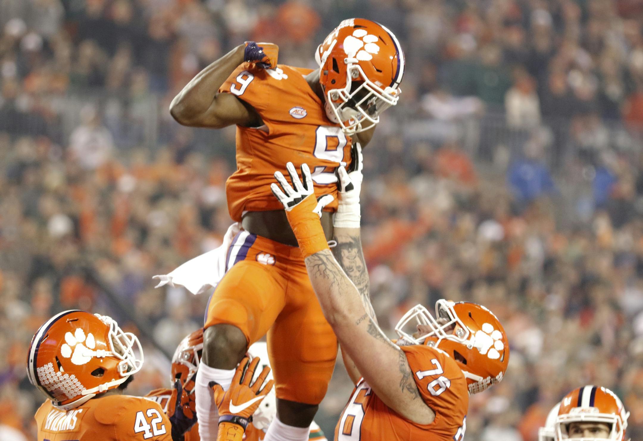Clemson's Travis Etienne (9) celebrates with teammates after his touchdown against the Miami during the first half of the Atlantic Coast Conference championship NCAA college football game in Charlotte, N.C., Saturday, Dec. 2, 2017. (AP Photo/Bob Leverone)