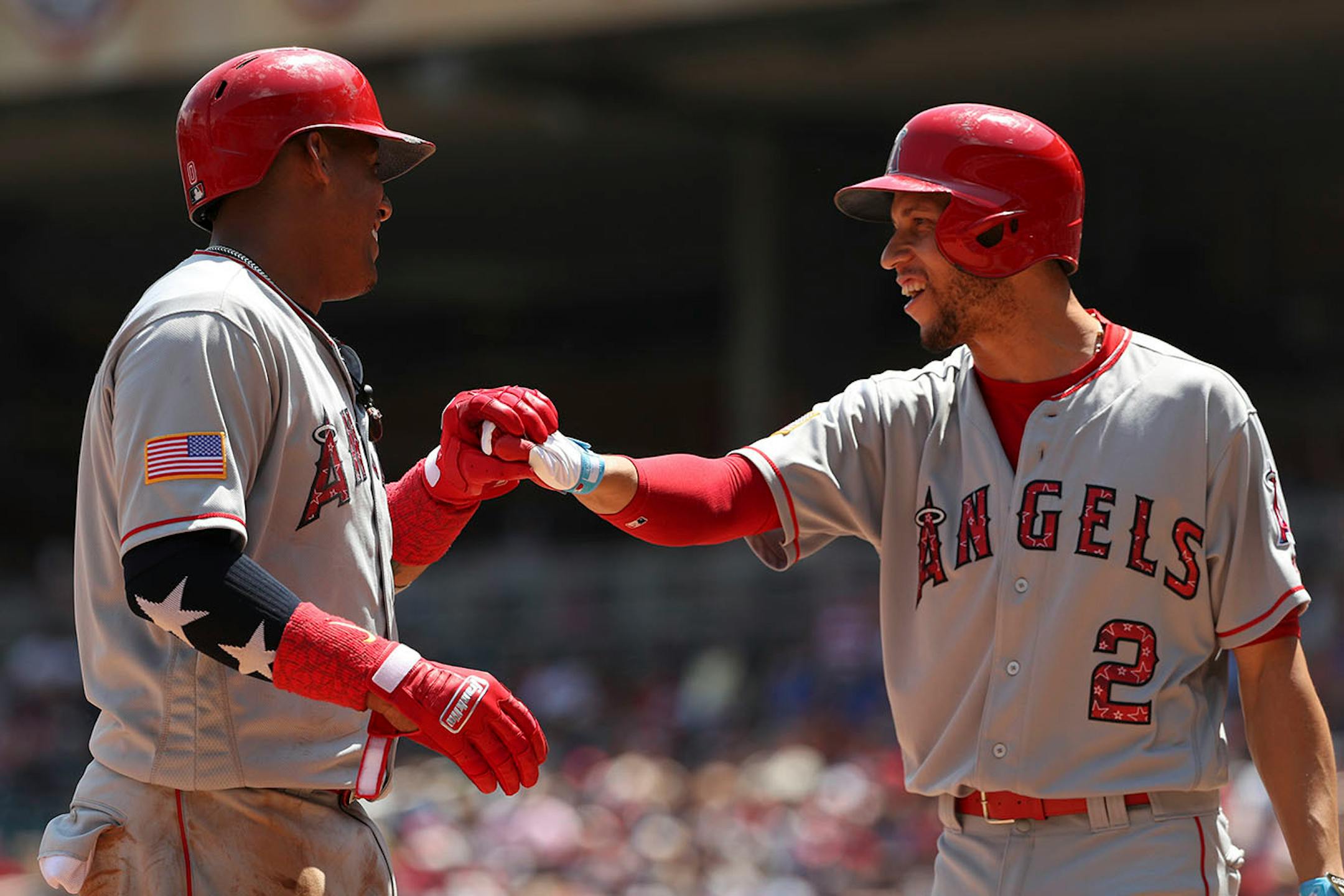 Los Angeles Angels third baseman Yunel Escobar (0) celebrated with Los Angeles Angels shortstop Andrelton Simmons (2) after he scored past Minnesota Twins catcher Chris Gimenez (38) in the second inning.