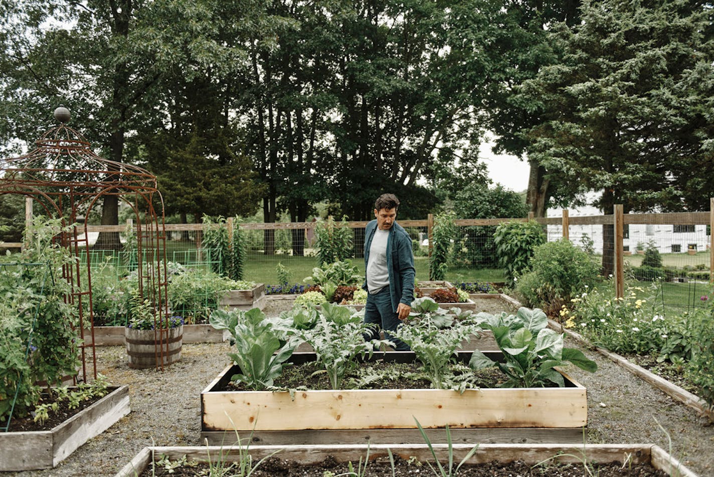 Jonathan Knight tends a vegetable garden at his farmhouse home in Essex, Mass., June 25, 2021. Now 52, Knight is balancing touring with a reunited ÒNew Kids on the BlockÓ with starring in ÒFarmhouse Fixer,Ó a home-renovation show on HGTV. (Tony Luong/The New York Times)