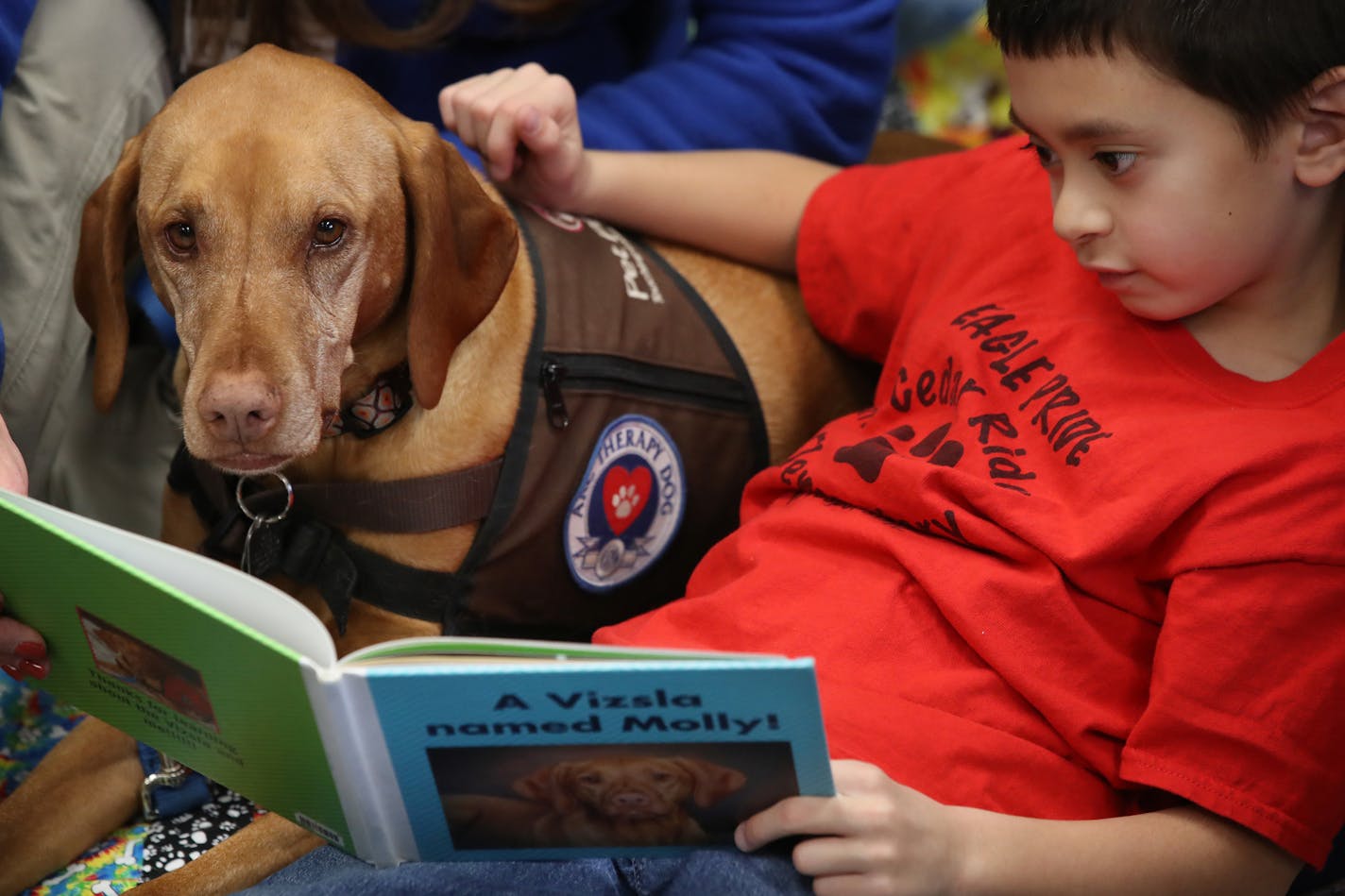 Kai Pat 7, read to Molly, a therapy dog, at Cedar Ridge Elementary School in Eden Prairie.