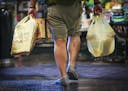 A man carried plastic bags of groceries out of Kowalski's in Uptown in Minneapolis, Minn., on Thursday, July 23, 2015.