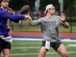 Gophers quarterback Max Brosmer, right, works with freshman Drake Lindsey, left, at Centennial High School on May 13 in Roswell, Ga.