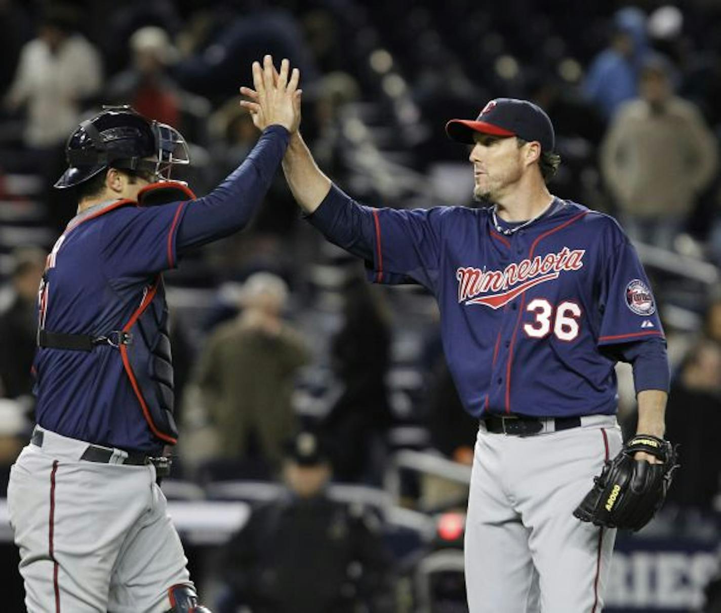 Minnesota Twins catcher Joe Mauer and relief pitcher Joe Nathan (36) celebrate the Twins' 5-4 victory over the New York Yankees in a baseball game at Yankee Stadium in New York, Tuesday, April 5, 2011. Mauer drove in the winning run in the 10th inning.