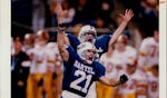 Photo taken Friday, November 25, 1994, by Jerry Holt. Published Saturday, November 26, 1994, page 1A. Published caption: Kicker Scott Mader (21) and h