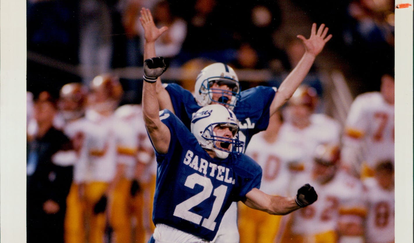 Photo taken Friday, November 25, 1994, by Jerry Holt. Published Saturday, November 26, 1994, page 1A. Published caption: Kicker Scott Mader (21) and his holder, Jeff Muntifering, were on top of the world after Mader's field goal gave Sartell the Class A championship during Friday's Prep Bowl XIII at the Metrodome. Mader kicked a 38-yard field with 13 seconds to play, lifting Sartell High School to a 24-21 victory over Northfield High School in the Class A championship game. Staff photo by Jerry Holt.