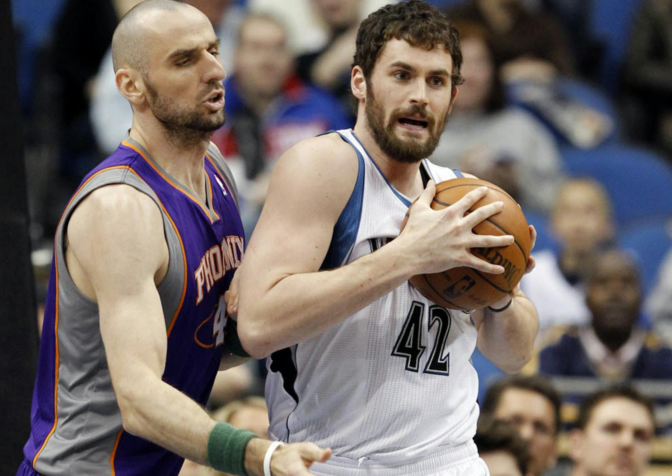 Minnesota's Kevin Love, right, grabs a rebound against Phoenix center Marcin Gortat.