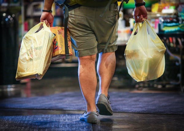 A man carried plastic bags of groceries out of Kowalski’s in Uptown in 2015.