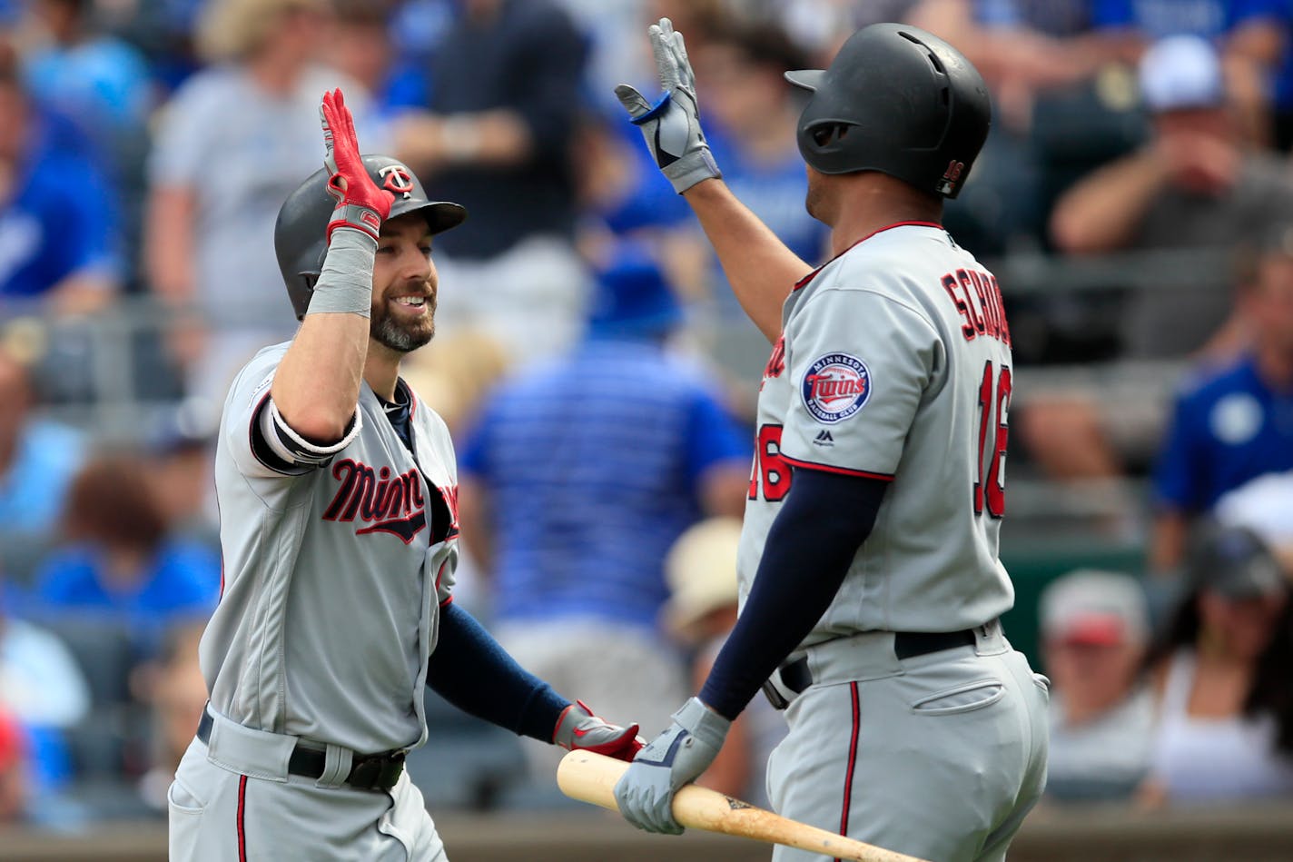 The Twins' Jake Cave, left, is congratulated by teammate Jonathan Schoop, right, following his solo home run during the first inning