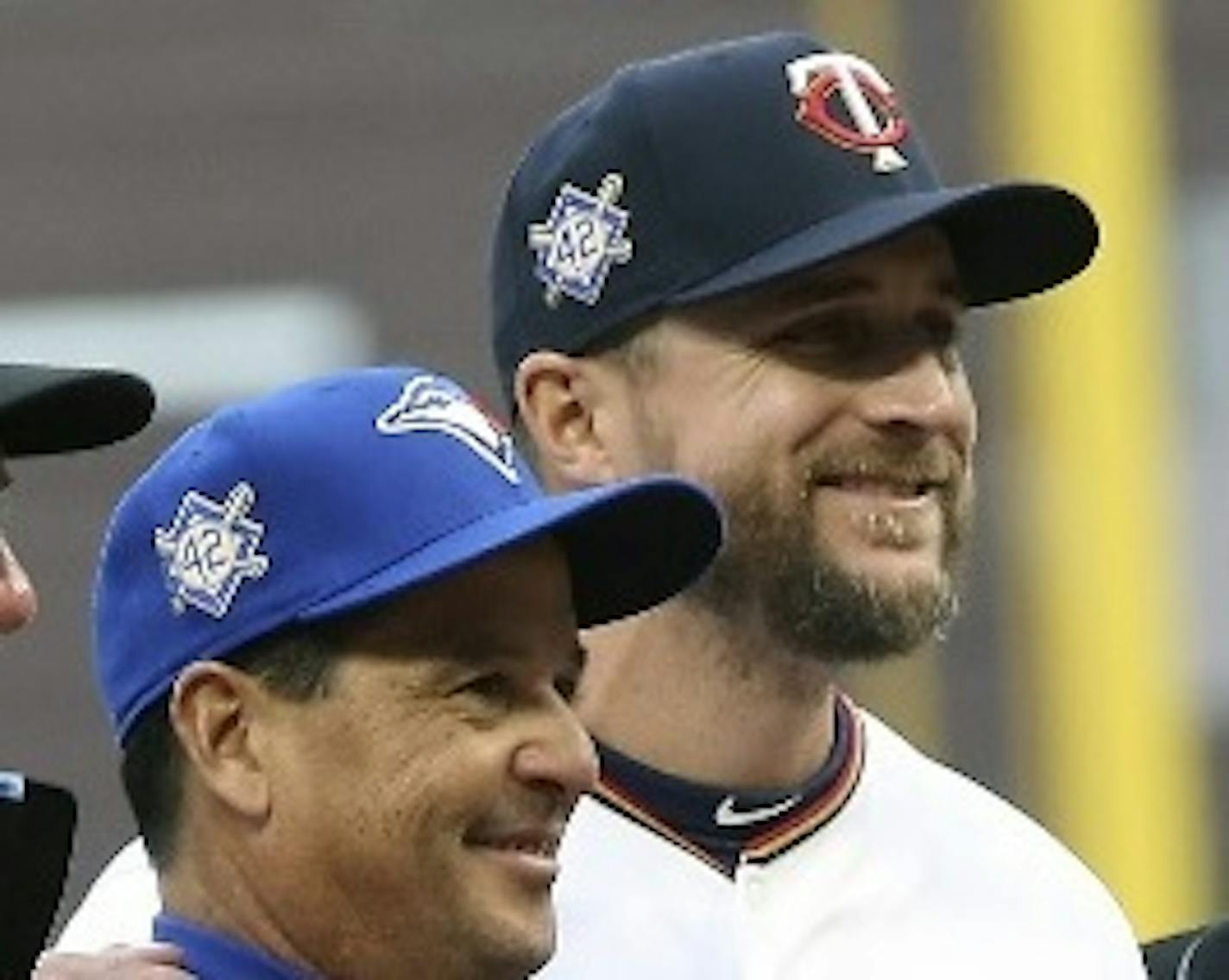 Blue Jays manager Charlie Montoyo, left, and Twins manager Rocco Baldelli posed with umpires before Monday's game at Target Field. The two friends were on Tampa Bay's coaching staff last season and spent several years in the Rays organization together.