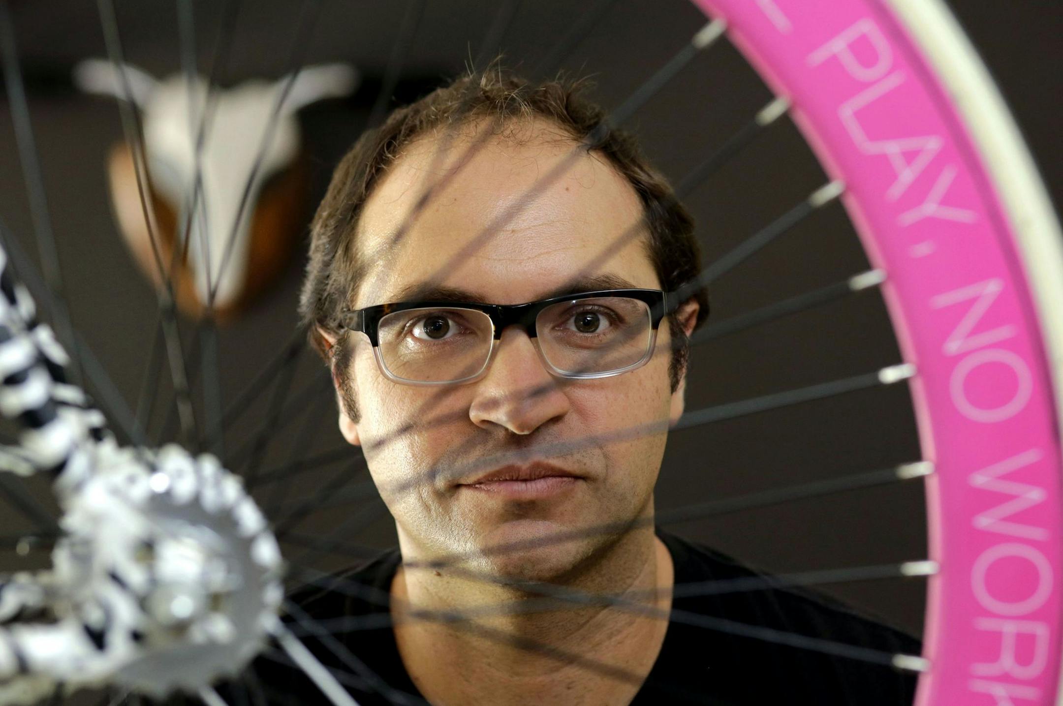 In this Tuesday, Aug. 4, 2015 photo, Avery Pack, president of Republic Bike, poses for a photograph with a custom, fixed gear bicycle manufactured at Republic Bike in Dania Beach, Fla. Companies, organizations and people are starting to forsake the familiar &#xec;.com&#xee; and &#xec;.org&#xee; Internet address suffixes, using instead hundreds of new ones like ".legal," ".movie," ".bike" and ".nyc" that have been coming on the market since early 2014. Using republic.bike is a good marketing stra