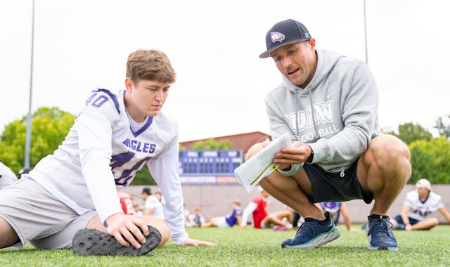 Northwestern tight end Nolan Howle listens to coaching from Boomer Roepke, the offensive coordinator for the University of Northwestern-St. Paul.