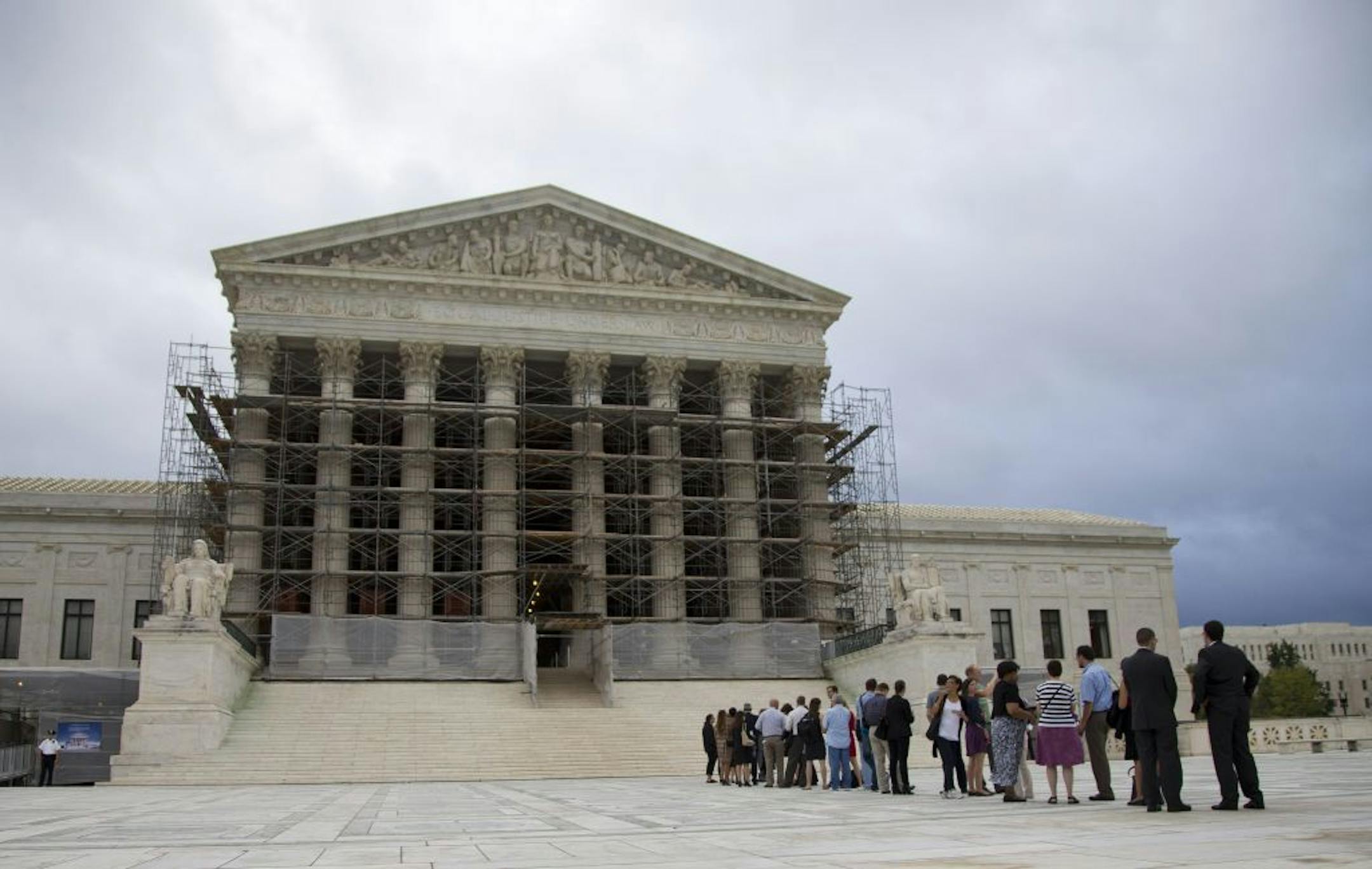 People wait in line for the beginning of the Supreme Court 2013-2014 opening term in Washington, Monday, Oct. 7, 2013. The justices take the bench Monday for the start of their new term with important cases about campaign contributions, housing discrimination and government-sanctioned prayer already on tap. Abortion, contraceptive coverage under the president's new health care law and mobile phone privacy also may find their way onto the court's calendar.