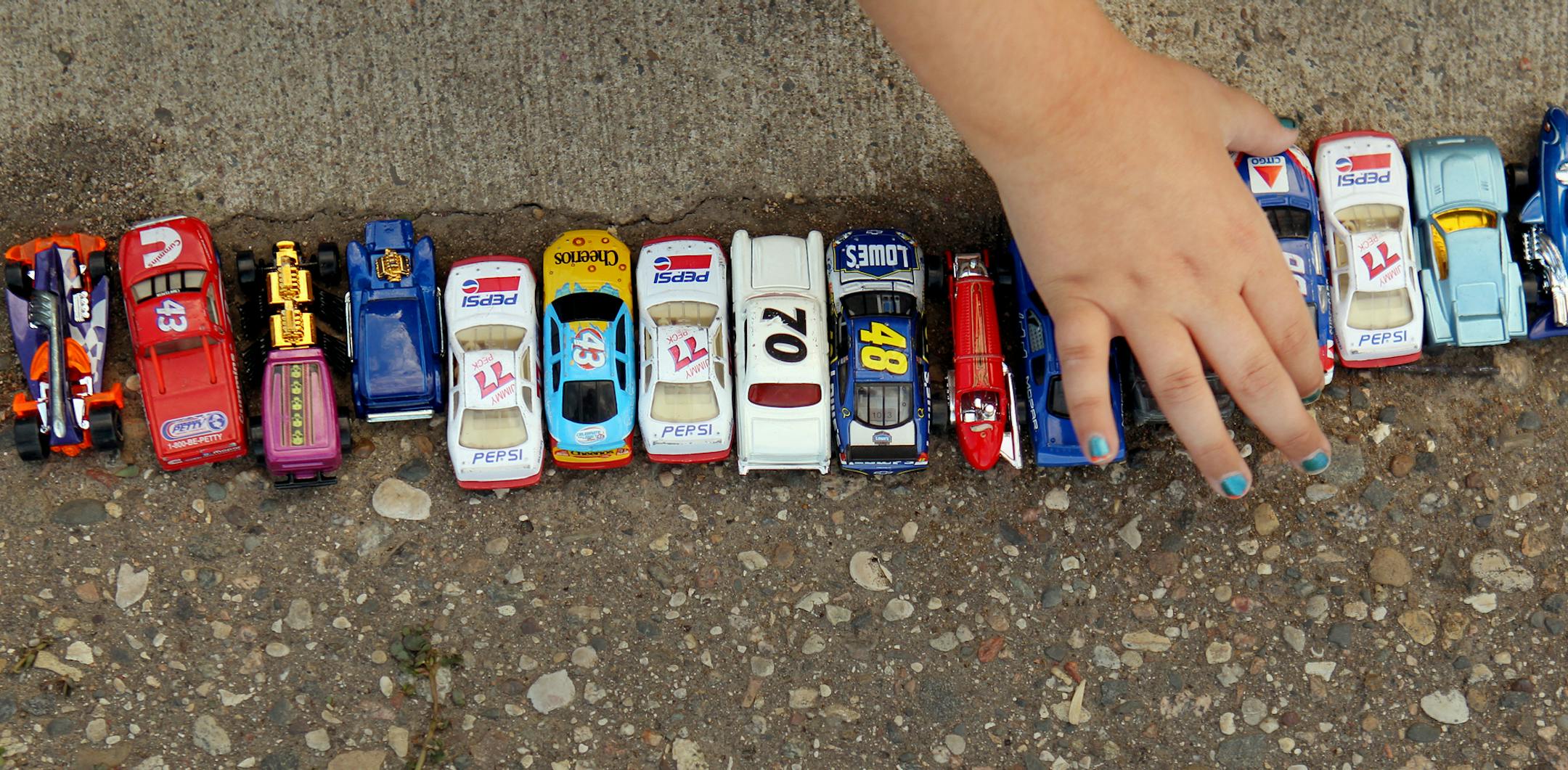 Jessica Ziemiecki, 9, of Corcoran, plays with her toy cars during the "Pack the Stands" event at Raceway Park in Shakopee, Minn., on Sunday, August 4, 2013. ] (ANNA REED/STAR TRIBUNE) anna.reed@startribune.com (cq)