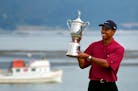 Tiger Woods holds the trophy after capturing the 100th U.S. Open at Pebble Beach in June of 2000